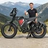 Rider Jake T. giving a thumbs up next to his POLEEJIEK bike in the mountains.