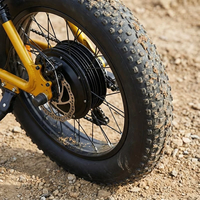 Close-up of a powerful 1500W rear hub motor and 4-inch fat tires on an electric dirt bike, illustrating high torque and stability for off-road riding.