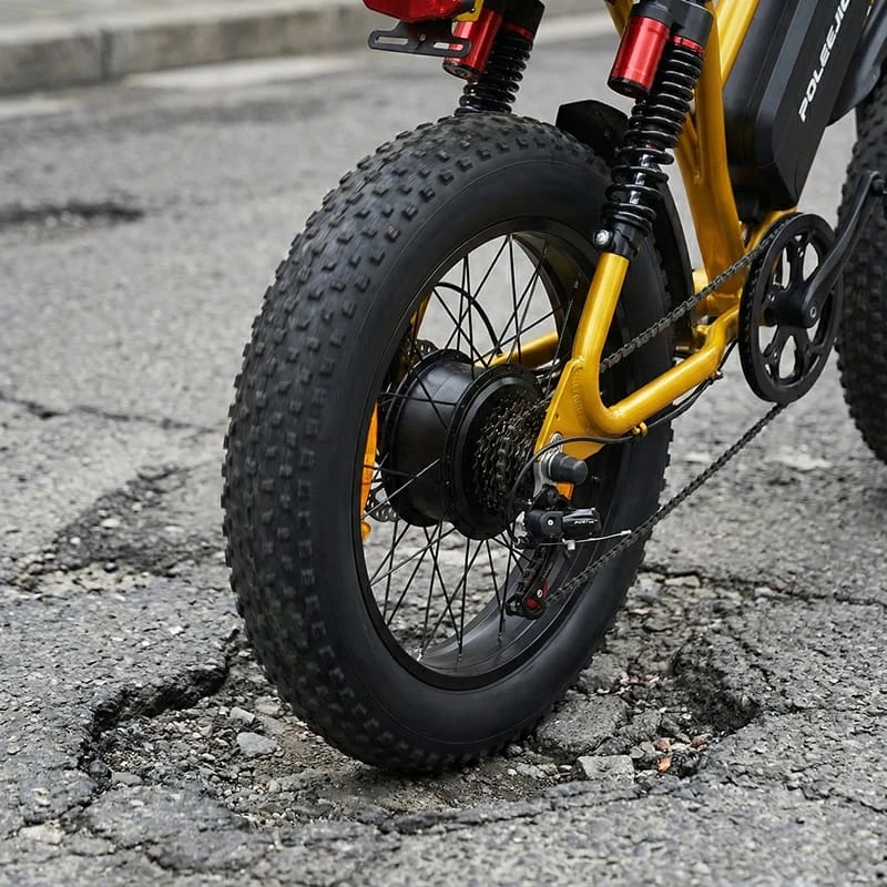 Close-up detail of POLEEJIEK F6 4-inch fat tires and rear suspension system designed for absorbing shock on urban roads.