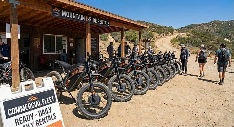 A fleet of Poleejiek electric dirt bikes lined up at a rental station near a mountain trail, showcasing robust fat tires and dual motors suitable for B2B rental businesses.
